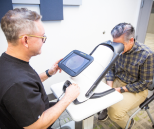 Optometrist utilizing IRIS screening software on patient